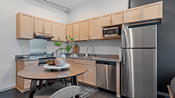 a kitchen with stainless steel appliances and a small table